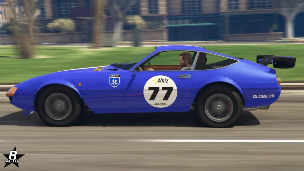 Vue latérale de la voiture rétro italienne "Grotti GT750" peinte en bleu et avec un autocollant indiquant le numéro de course "77" dans un rond blanc sur la portière.