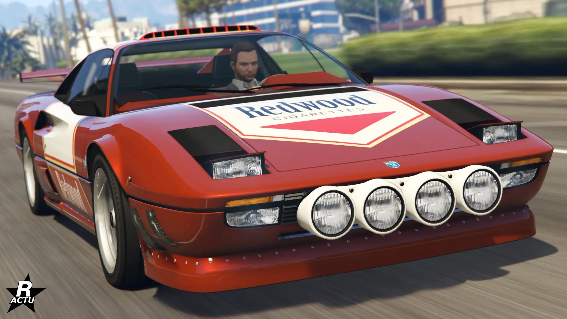 L'avant de la voiture italienne Grotti Itali Classique dans une customisation de rallye. La carrosserie est peinte en rouge, un autocollant blanc Redwood se trouve sur le capot et des phares supplémentaires sont incrustés dans le pare-chocs.