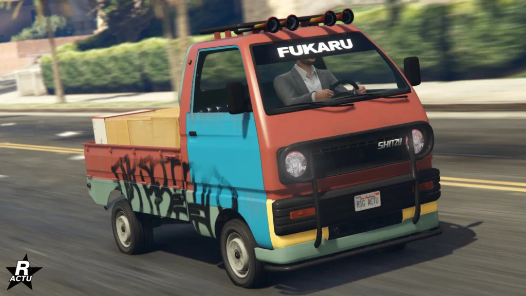 Camionnette Shitzu Keitora vue de devant, elle est peinte en rouge, sauf sa portière qui est bleue. Les côtés latéraux sont tagués.