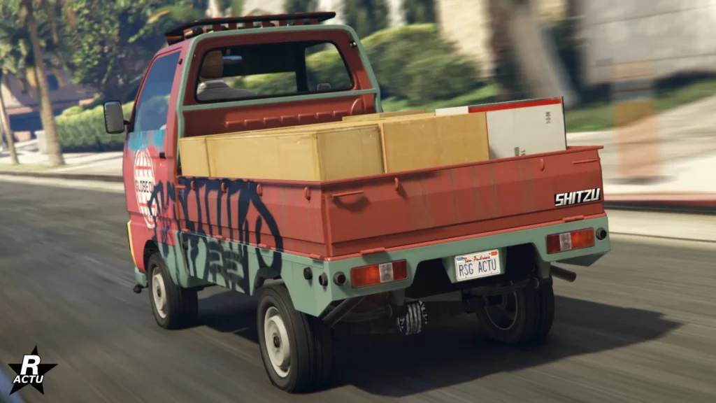 Vue arrière du véhicule à plateau Shitzu Keitora dans GTA Online. Le bolide japonais est peint en rouge et des cartons sont présents dans le plateau arrière.