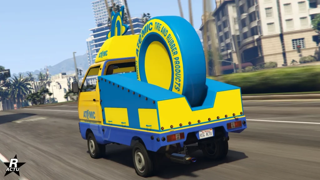 Vue arrière du véhicule de GTA Online peint en jaune et bleu, avec un pneu géant Atomic dans le plateau arrière.