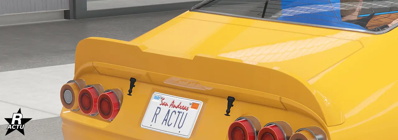 Aileron plat épousant les lignes de la carrosserie avec des arrondis aux extrémités, et une encoche au centre de l'aileron.