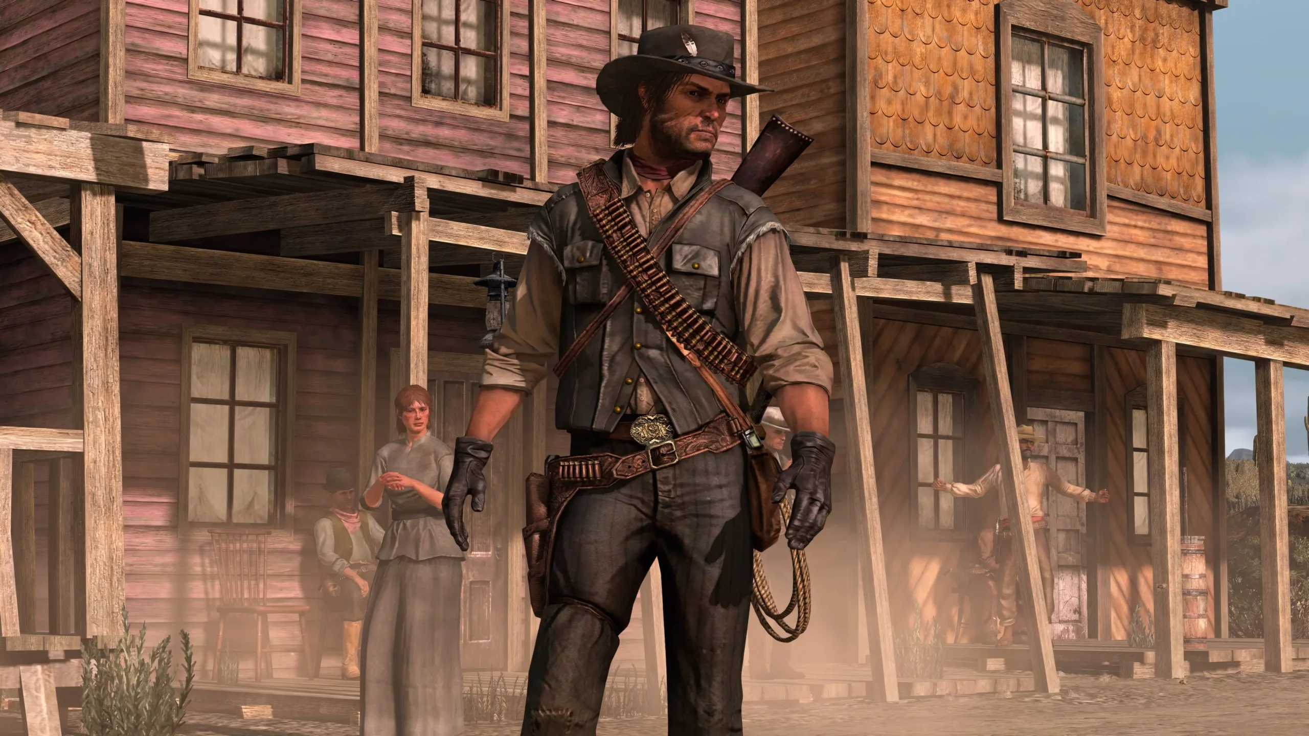 John Marston dans les rues d'Armadillo avec des PNJ et des maisons en bois en arrière plan.