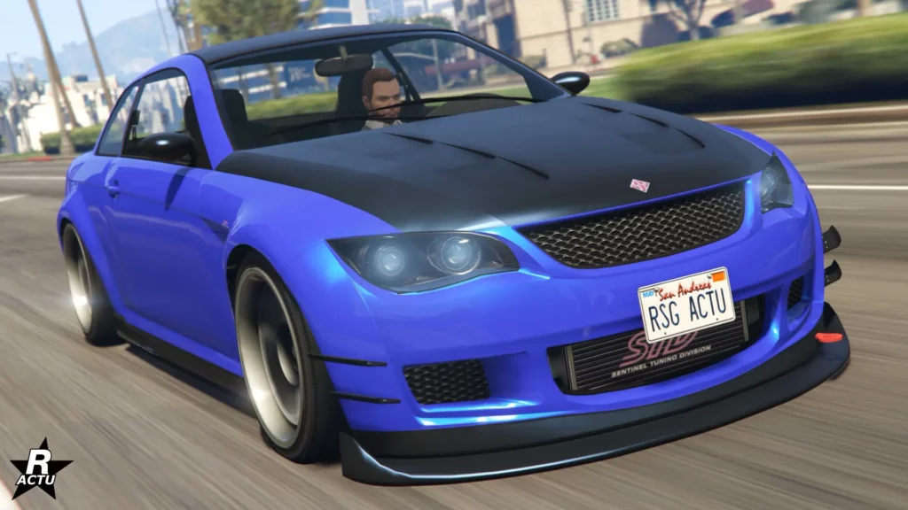 Vue avant du véhicule Ubermacht Sentinel XS roulant sur une route ensoleillée du jeu vidéo GTA Online. La voiture allemande à sa carrosserie peinte en bleu, à l'exception du capot et du toit, qui sont peint en noir. Le capot du bolide dispose de deux rangée d'aérations pour le moteur.