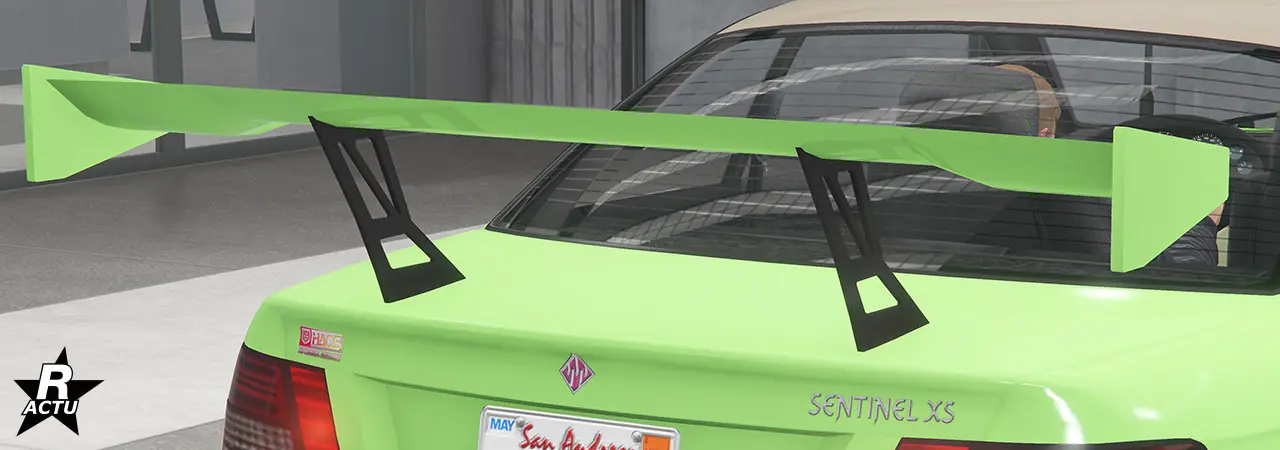 Option d'aileron GT large peint dans la couleur principale, suspendu en hauteur au-dessus du coffre avec une double fixation en fibres de carbone noires.