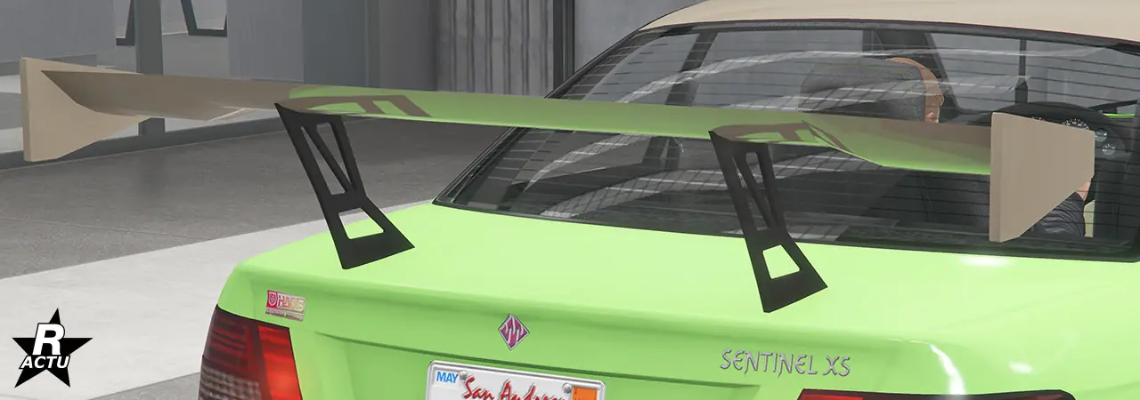 Option d'aileron GT large peint dans la couleur secondaire, suspendu en hauteur au-dessus du coffre avec une double fixation en fibres de carbone noires.