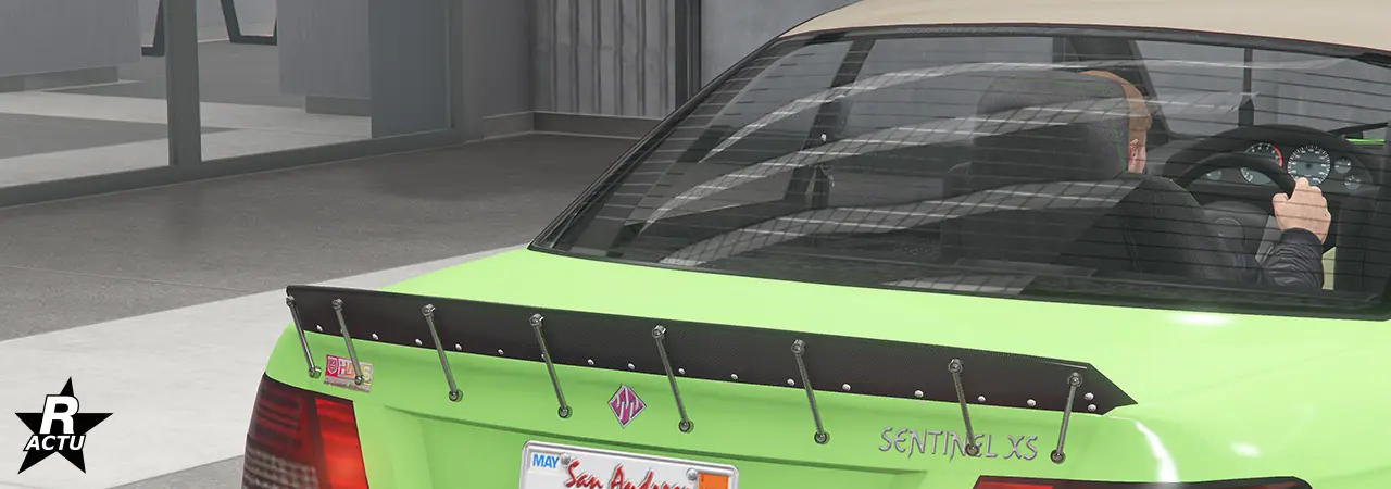 Option d'aileron en fibres de carbone noires en forme de bec de canard, vissé à l'extrémité du coffre du véhicule.