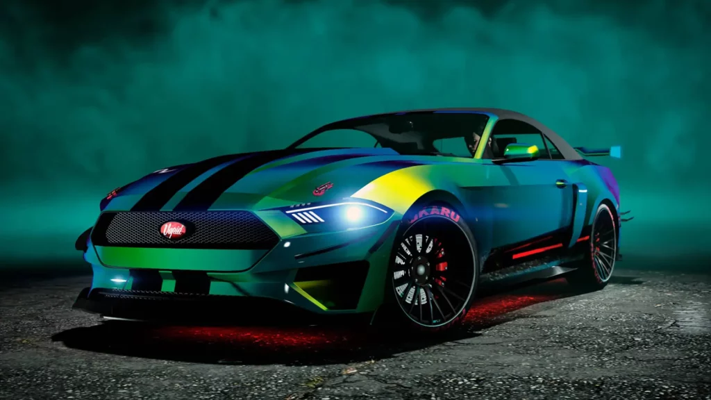 Vue avant de la voiture Vapid Dominator GT dans le jeu vidéo GTA Online. Le véhicule dispose d'une peinture caméléon aux nuances de verts et bleues avec une décalcomanie d'une double bande noire verticale au centre de sa carrosserie. Sous la grosse cylindrée, se trouve des néons rouges. En arrière plan, de la fumée entoure le véhicule dans la pénombre.