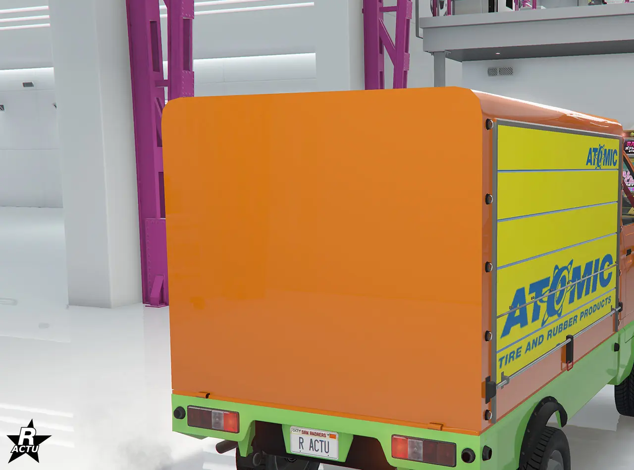 Option de personnalisation, remplaçant le plateau arrière de la camionnette, par une benne de stockage avec volets déroulant latéraux jaune surmontés du logo de l'entreprise de pneumatiques « Atomic ».