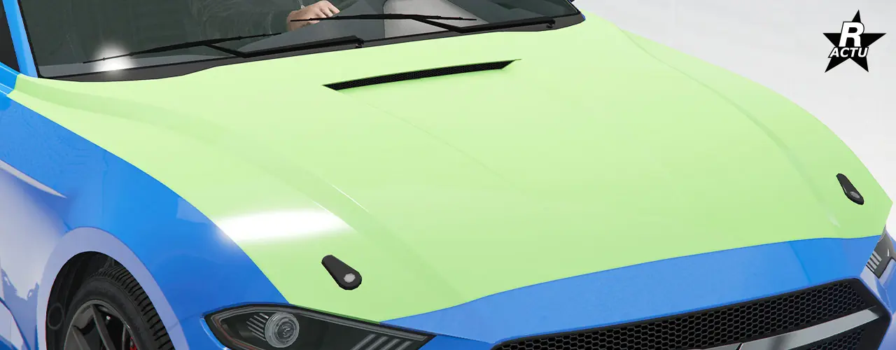 Capot couleur secondaire avec un affaissement au centre donnant sur une large ventilation rectangulaire. Sur la partie avant, une attache capot noire rectangulaire se trouve du côté droit et du côté gauche.