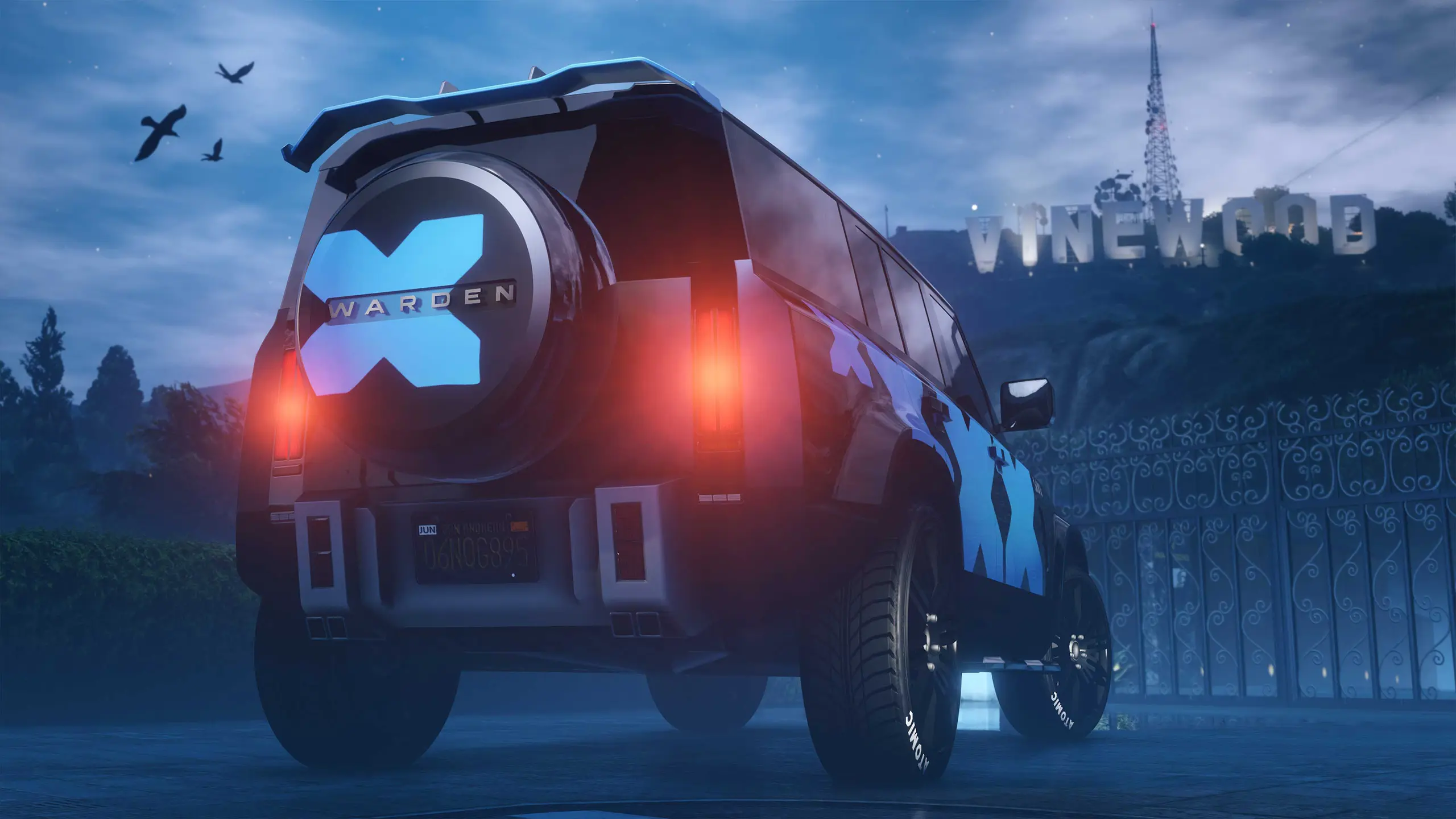 Image du véhicule britannique Gallivanter Warden, vue de l'arrière de sa carrosserie peinte en noir et qui dispose du motif "XX" qui ajoute deux X bleu en autocollant sur la voiture. La photo a été prise depuis la cour d'une villa de Vinewood d'un joueur de GTA Online.