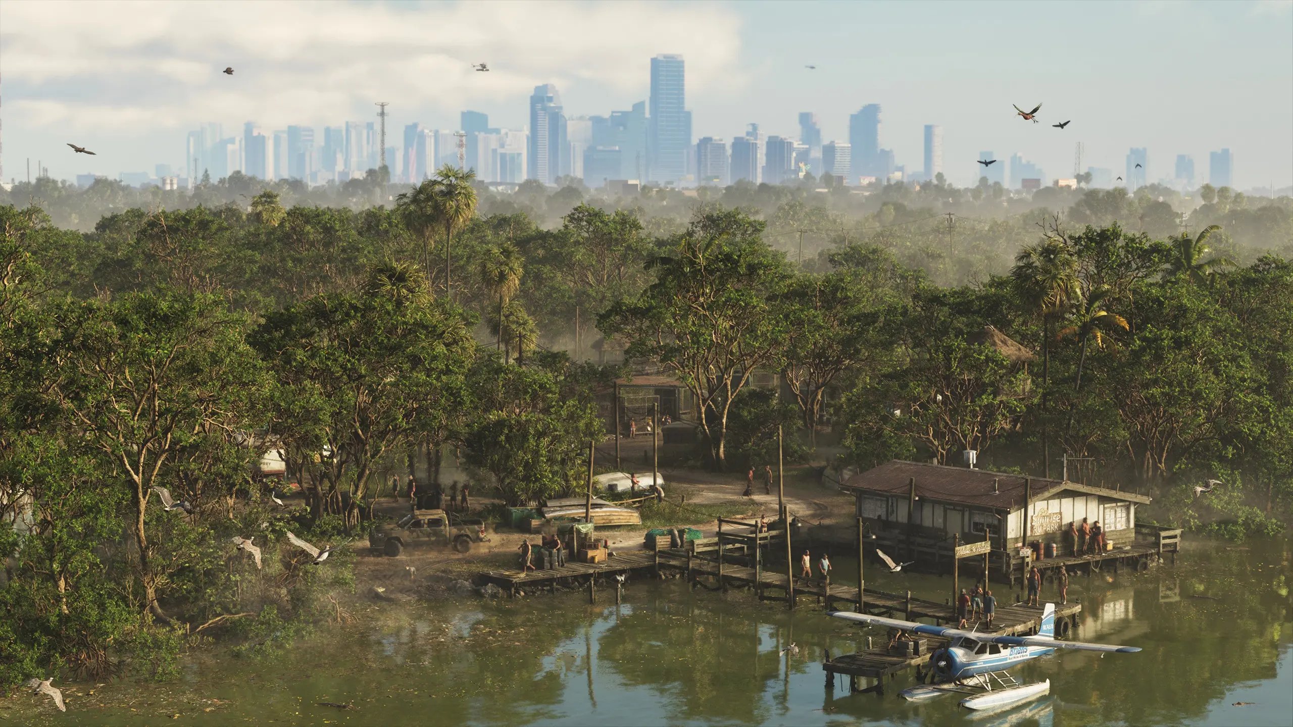 Vue aérienne d'une zone marécageuse avec des cabanes en bois en premier plan, et la ville de Vice City au loin.