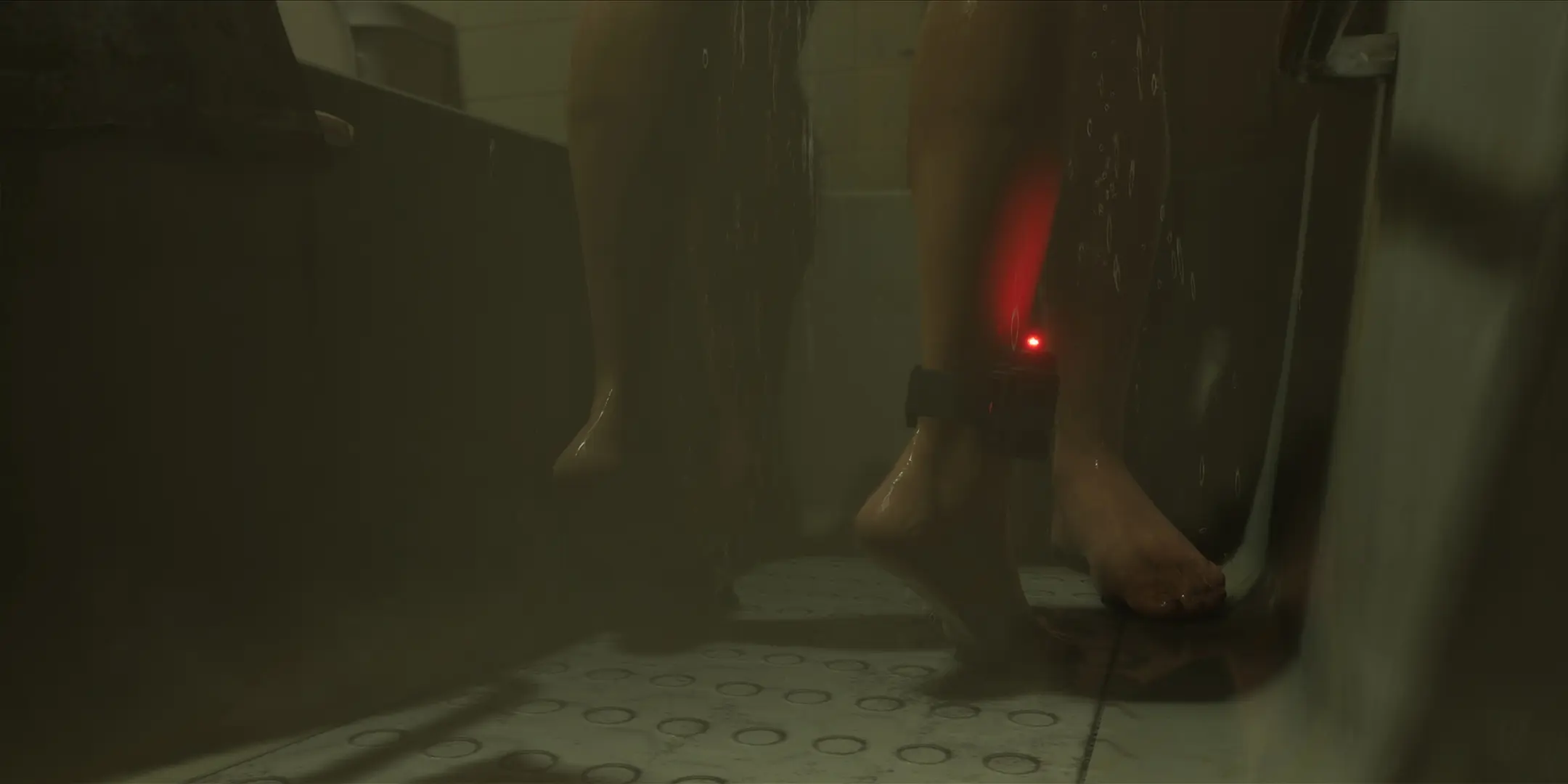 Gros plan sur le bracelet électronique de Lucia à sa cheville.