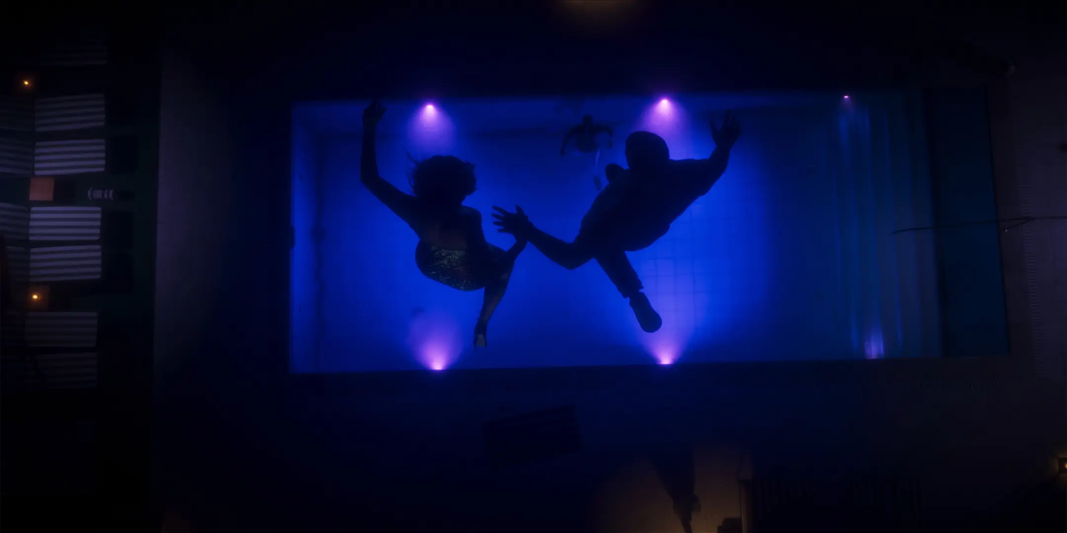 Lucia et Jason sautant dans une piscine, main dans la main.