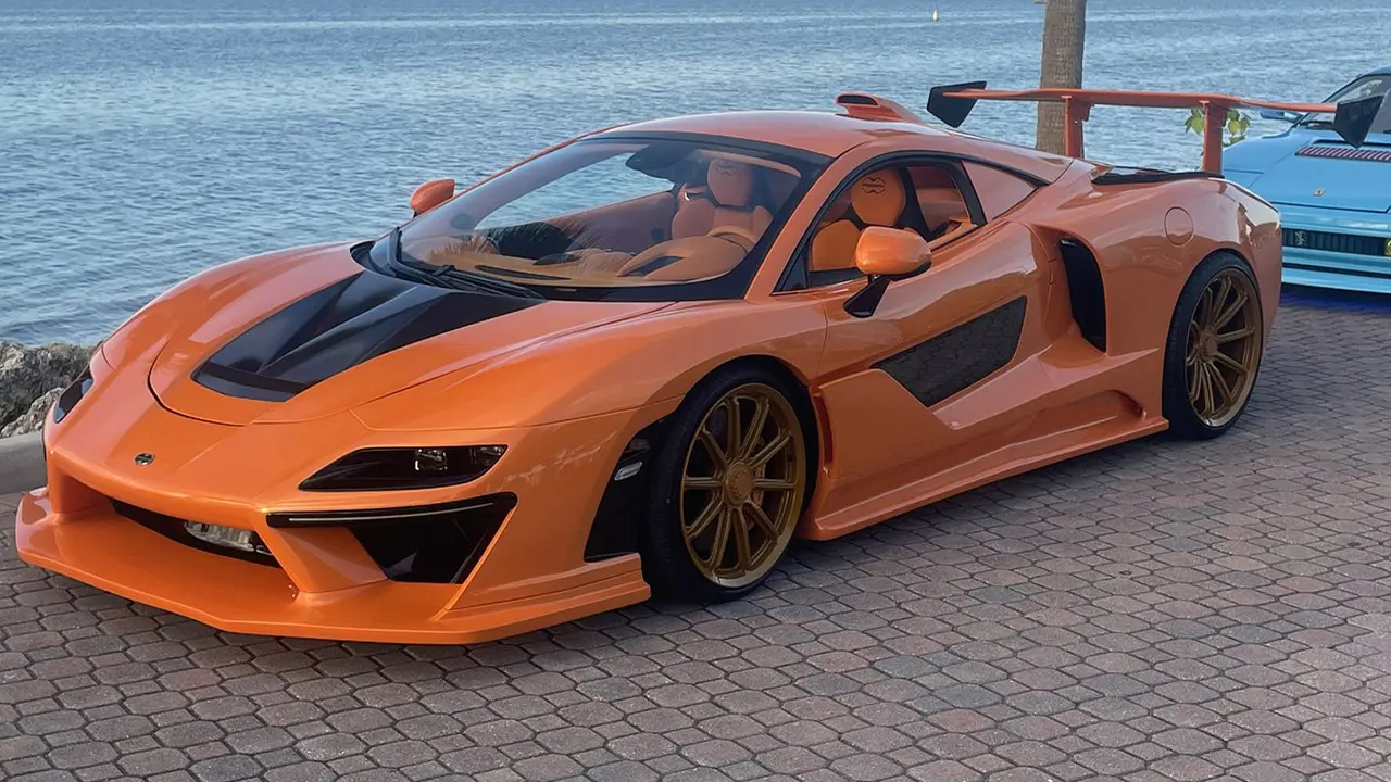 Progen Emerus existant IRL exposé le long d'une route de Miami. Elle est peinte en orange avec le logo Progen sur le capot et sur les finitions des sièges intérieur de cette McLaren transformée.